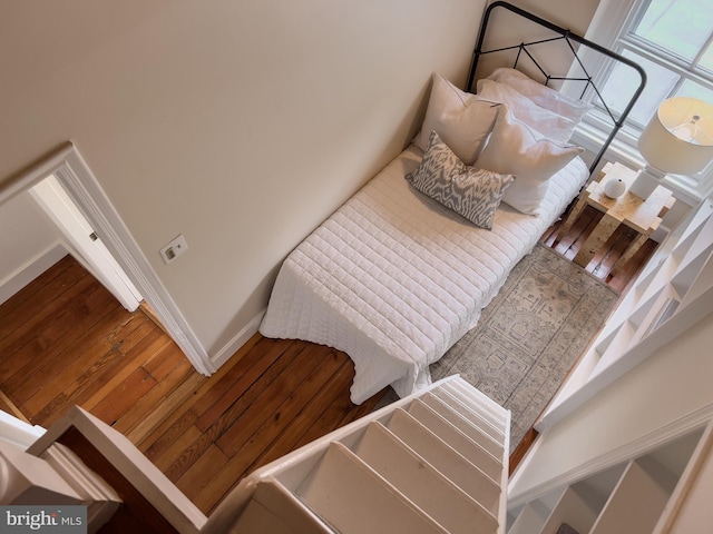 bedroom featuring baseboards and hardwood / wood-style flooring