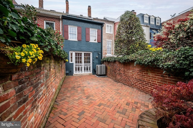 rear view of property with a patio, brick siding, and central AC