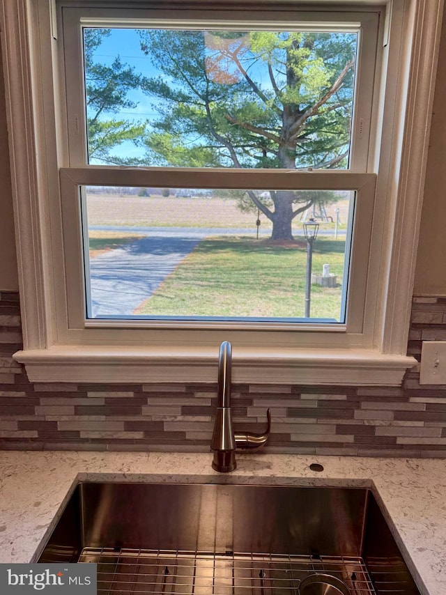 interior details featuring a sink and light stone counters
