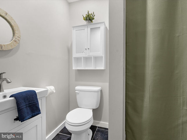 full bath featuring a shower with shower curtain, baseboards, toilet, a sink, and tile patterned flooring