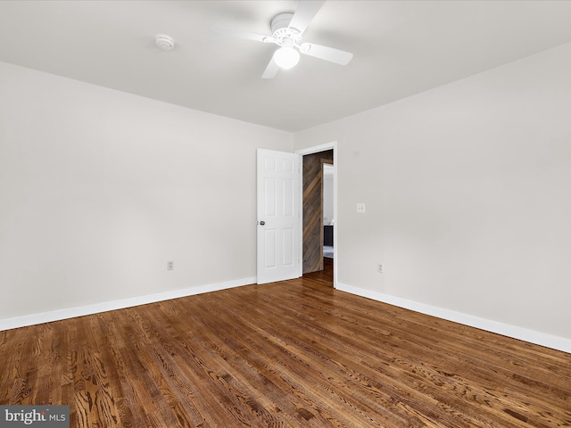 empty room with baseboards, wood finished floors, and a ceiling fan