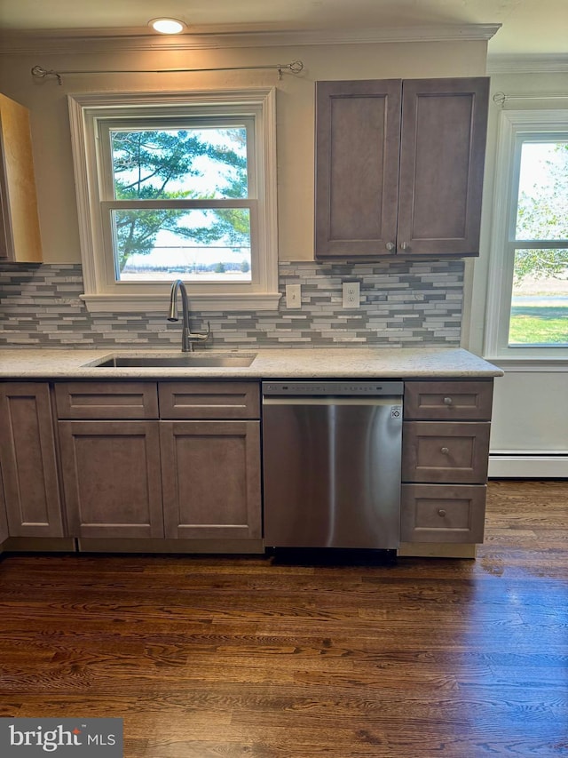 kitchen with light countertops, dishwasher, dark wood-type flooring, a sink, and a baseboard heating unit