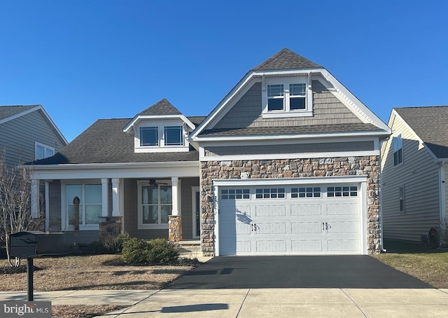 view of front of home featuring stone siding, roof with shingles, and driveway