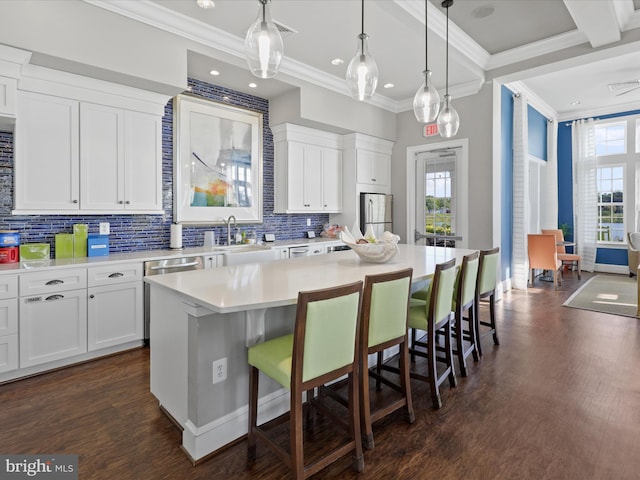 kitchen featuring white cabinets, a breakfast bar, a kitchen island, and light countertops