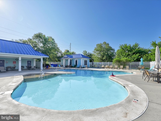 community pool featuring a patio area and fence