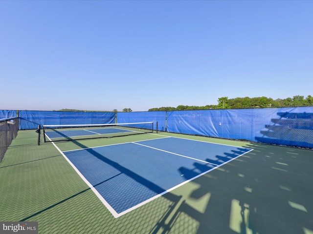 view of tennis court featuring fence