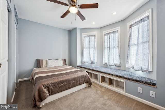 bedroom with ceiling fan, carpet flooring, and multiple windows