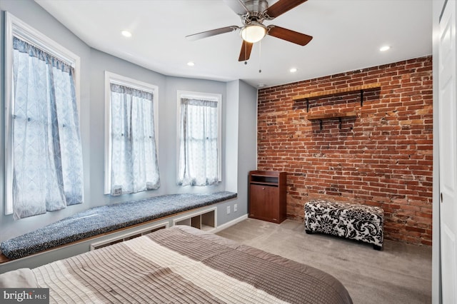 interior space with ceiling fan and brick wall