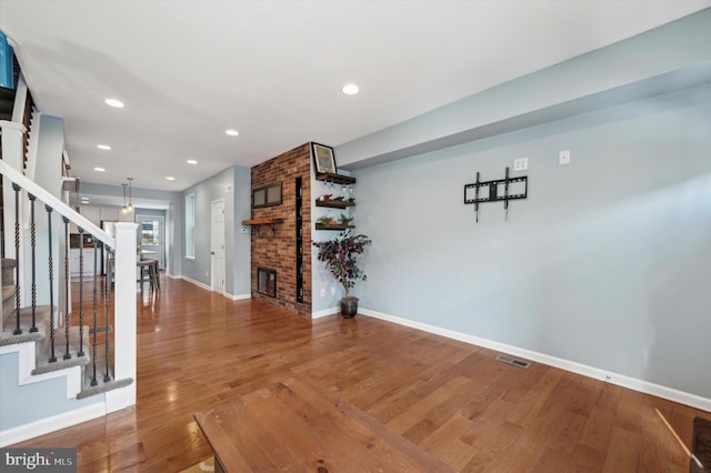 interior space featuring hardwood / wood-style flooring and a brick fireplace