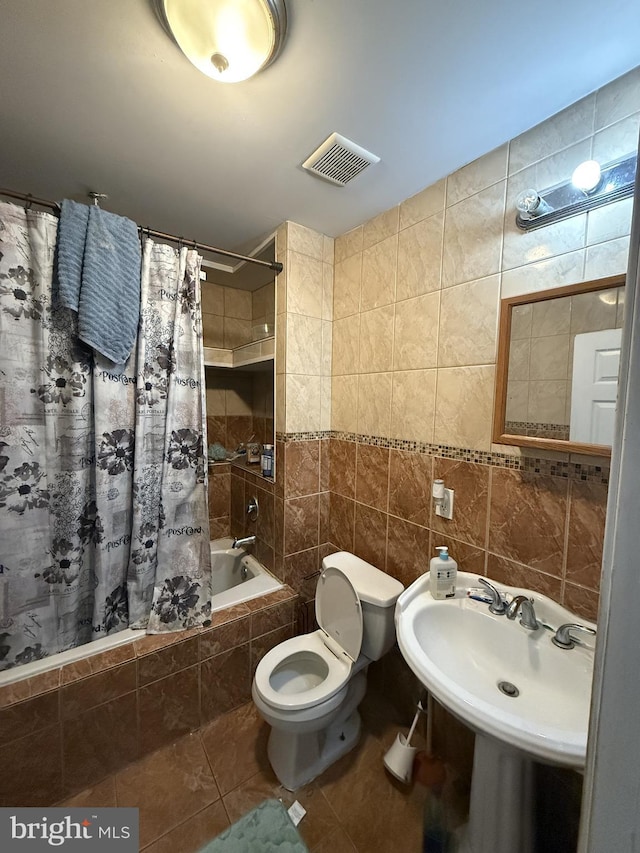 full bathroom featuring toilet, sink, tile walls, shower / bath combination with curtain, and tile patterned flooring