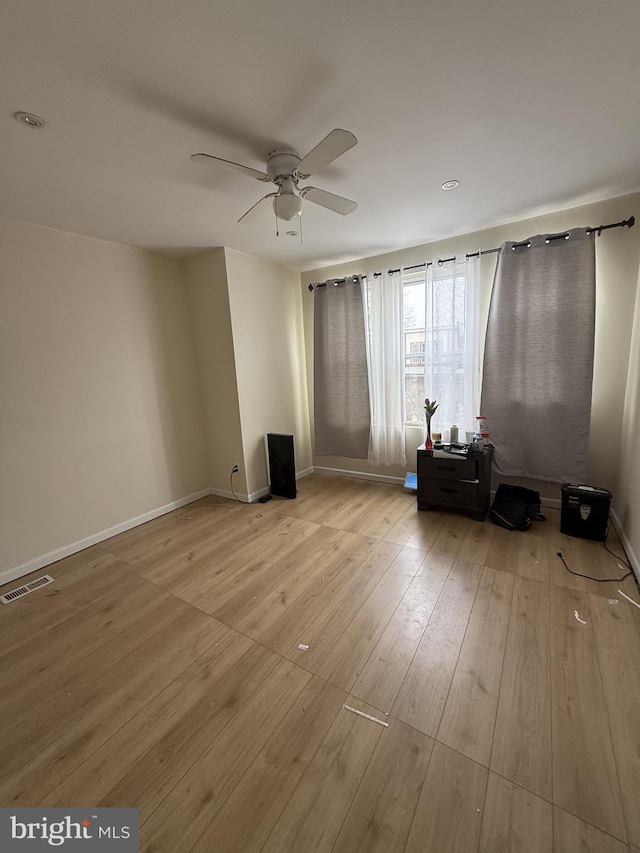 empty room featuring ceiling fan and light hardwood / wood-style flooring