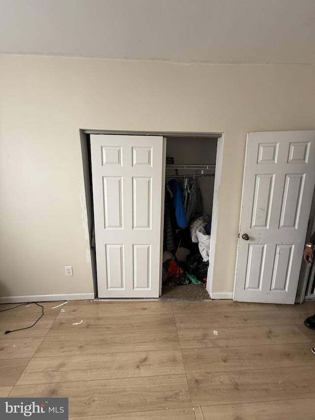 unfurnished bedroom with light hardwood / wood-style floors and a closet