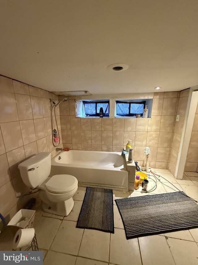 bathroom featuring tile walls, tile patterned floors, and toilet