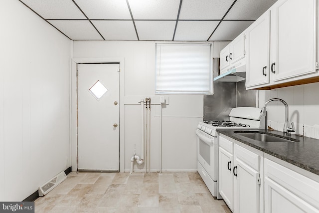 kitchen featuring a paneled ceiling, sink, white range with gas stovetop, and white cabinets