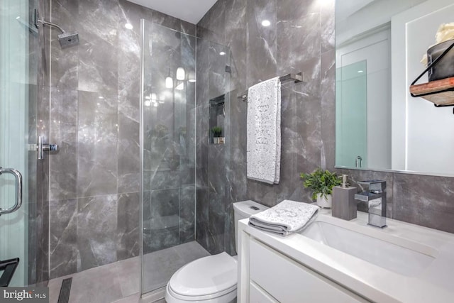 bathroom with walk in shower, tile walls, vanity, and toilet