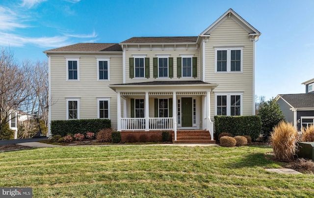 view of front of home with covered porch and a front lawn