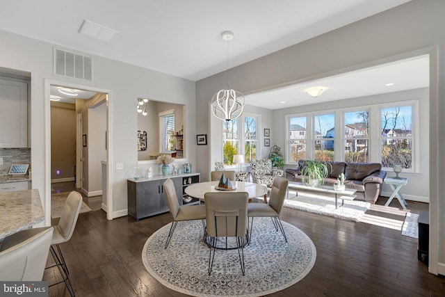 dining room featuring dark wood-type flooring and an inviting chandelier