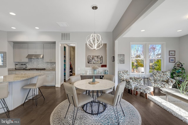 dining space featuring a notable chandelier and dark hardwood / wood-style floors