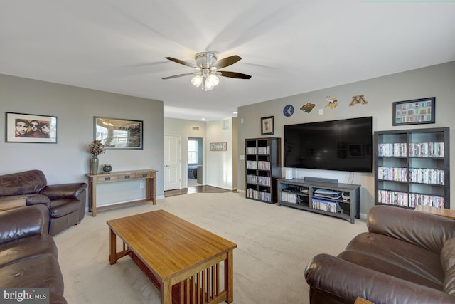 carpeted living room with ceiling fan