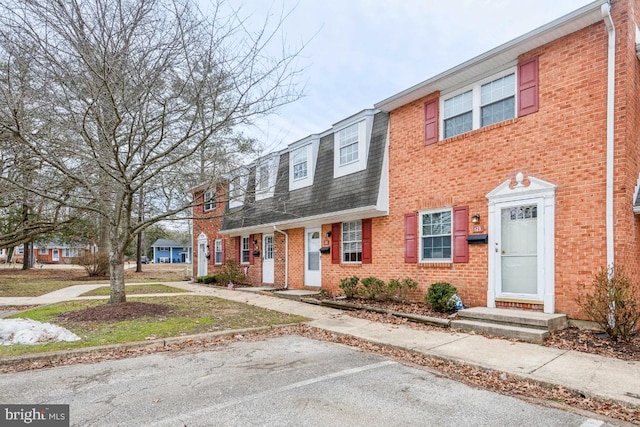 townhome / multi-family property with brick siding and roof with shingles