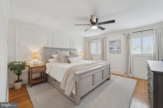 bedroom featuring ornamental molding, ceiling fan, and light wood-type flooring