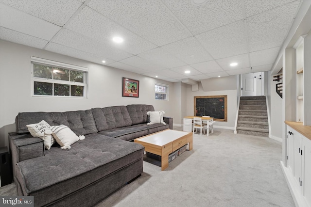 living room featuring a paneled ceiling and light colored carpet