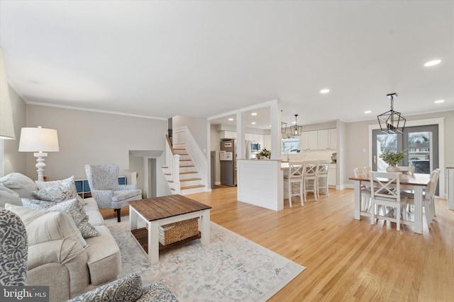 living room featuring crown molding and light hardwood / wood-style flooring