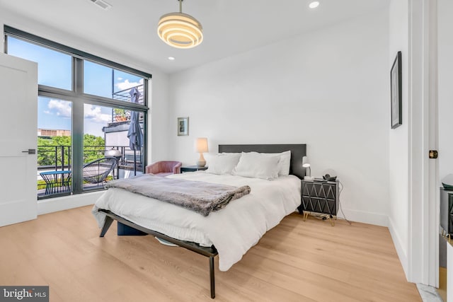 bedroom with access to outside and light wood-type flooring