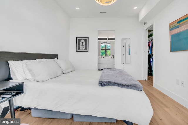 bedroom featuring hardwood / wood-style flooring and a spacious closet