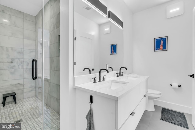 bathroom featuring tile patterned floors, vanity, toilet, and a shower with shower door