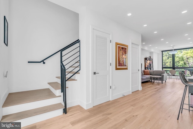 stairway featuring hardwood / wood-style flooring and expansive windows