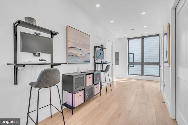 hallway featuring electric panel and light wood-type flooring