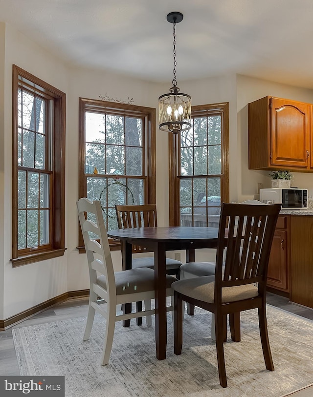 dining space with a notable chandelier, plenty of natural light, and light hardwood / wood-style floors