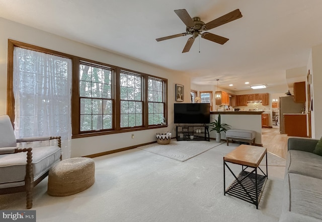 carpeted living room with ceiling fan