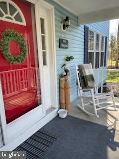 view of exterior entry featuring covered porch