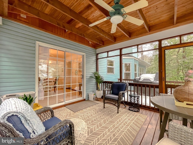 sunroom featuring ceiling fan, wooden ceiling, and beamed ceiling