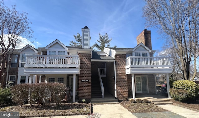 view of front of home with brick siding and a chimney