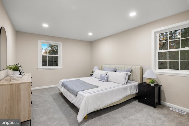 bedroom with light colored carpet, visible vents, baseboards, and recessed lighting