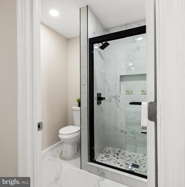 bathroom featuring a marble finish shower, marble finish floor, baseboards, and toilet