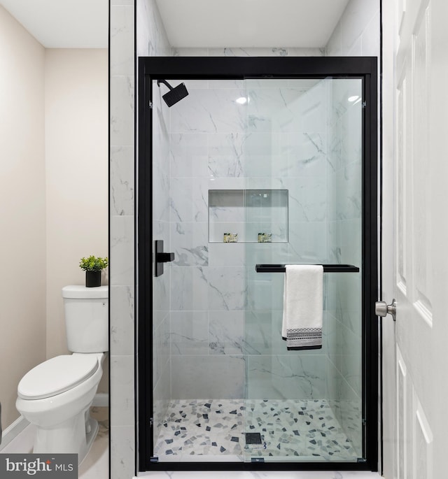 bathroom with a shower stall and toilet