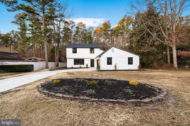 modern inspired farmhouse with concrete driveway and fence