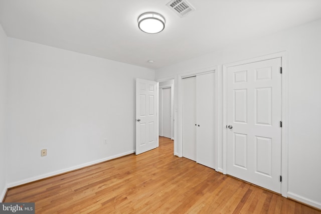 unfurnished bedroom featuring a closet and light wood-type flooring