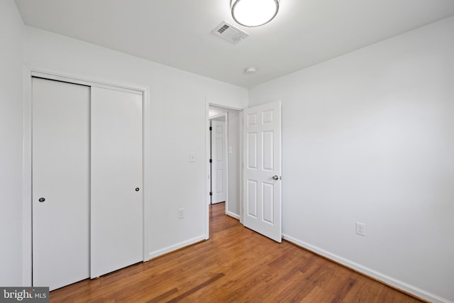 unfurnished bedroom with hardwood / wood-style floors and a closet