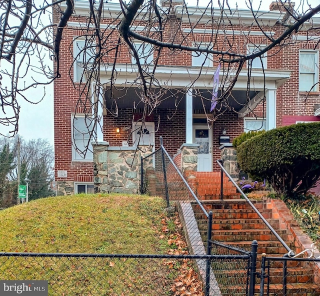 view of front facade featuring covered porch and brick siding