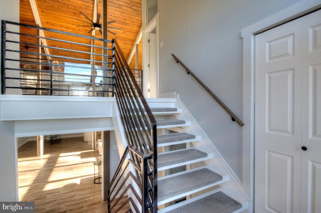 stairs featuring wood ceiling, vaulted ceiling, and hardwood / wood-style floors