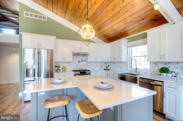 kitchen featuring white cabinetry, stainless steel appliances, and a center island