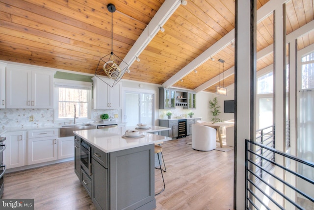 kitchen with pendant lighting, a center island, sink, and white cabinets