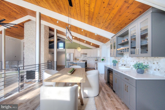 kitchen with wood ceiling, light hardwood / wood-style flooring, hanging light fixtures, vaulted ceiling with beams, and decorative backsplash