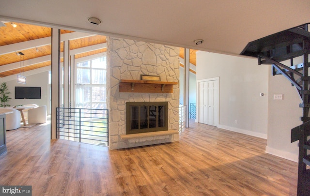 living room featuring vaulted ceiling with beams, hardwood / wood-style floors, wooden ceiling, and a fireplace