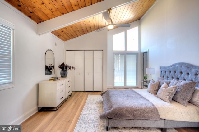 bedroom featuring lofted ceiling with beams, light hardwood / wood-style flooring, ceiling fan, wood ceiling, and a closet